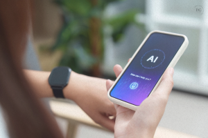 Person holding a smartphone displaying an AI assistant interface, with the text “How can I help you?” and wearing a smartwatch on their wrist.
